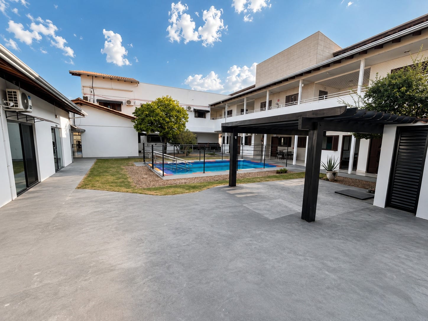Pátio interno do Casannova, com pergolado, jardim e piscina